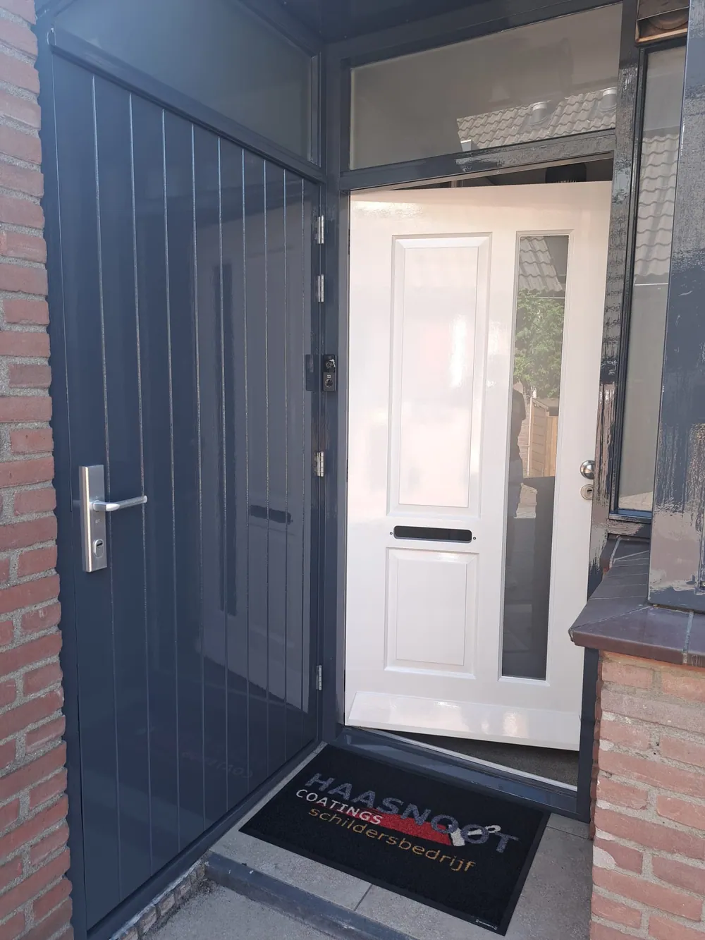 Zwart-wit geschilderde entree met hoogglans afwerking